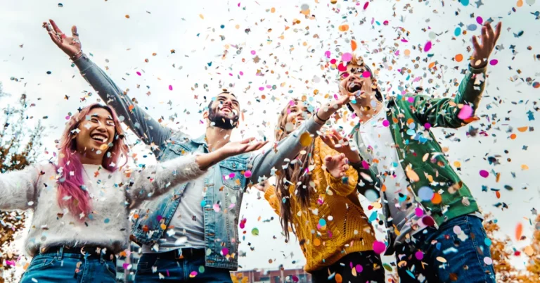 Students having fun together at college campus celebrating being named National Merit Scholars by throwing confetti