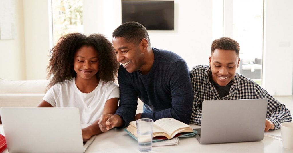 Looking for Test Prep for Your Child? Here’s What’s at Stake. Parent helping his teens with homework on laptops.