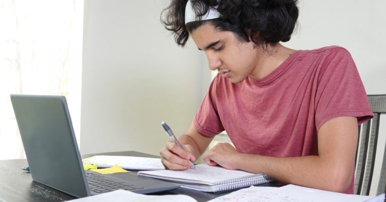Teenage boy getting homeschooling virtually