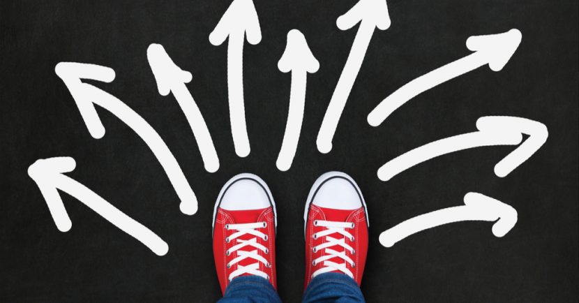 Feet wearing red shoes on black background with arrows in different direction