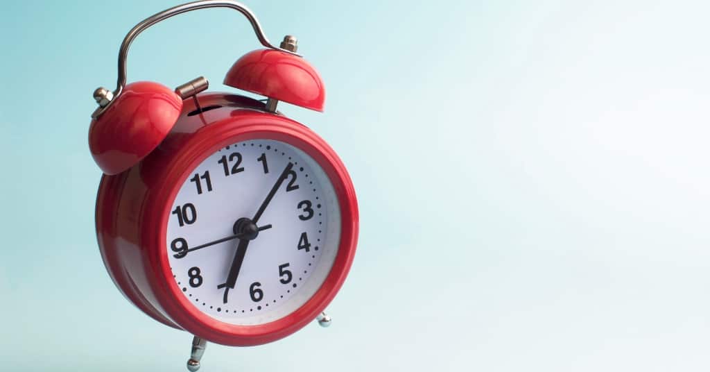 Photo of red analog alarm clock