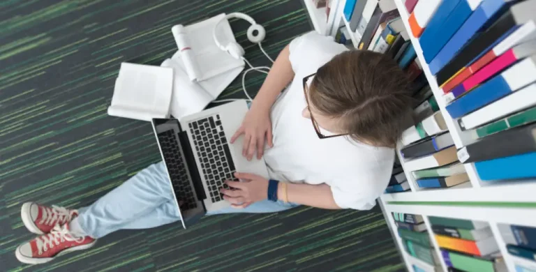 A student reads the UWorld Digital SAT® Math Study guide, showcasing algebra, geometry, and statistics, to learn how to enhance their math skills.